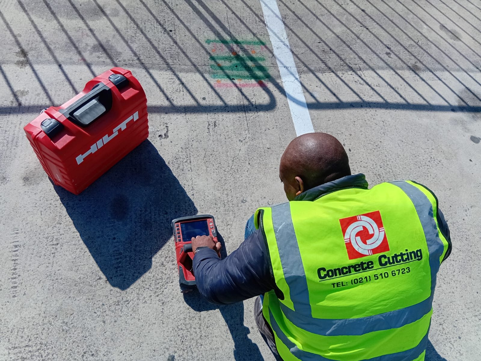 CCS concrete scanning technician operating Hilti equipment on a marked slab