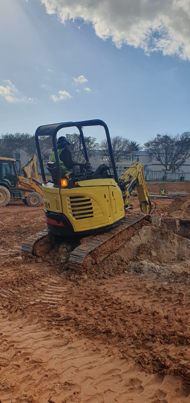 Compact excavator working on a foundation excavation